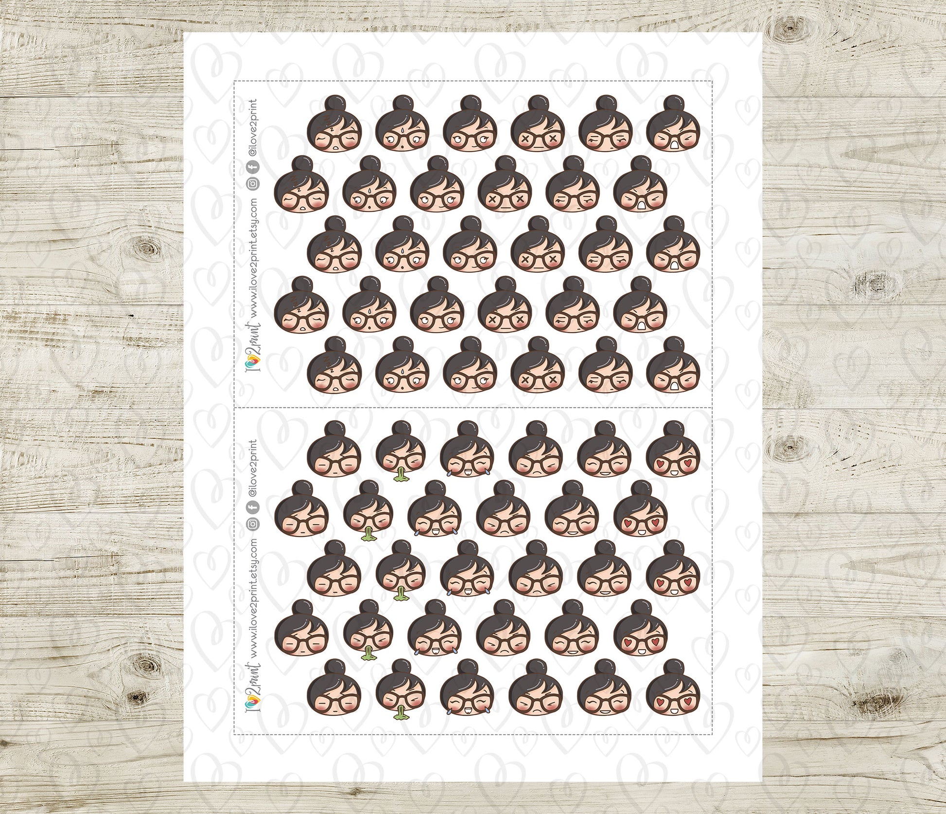 Sheet of planner stickers with woman face emojis on a wooden surface