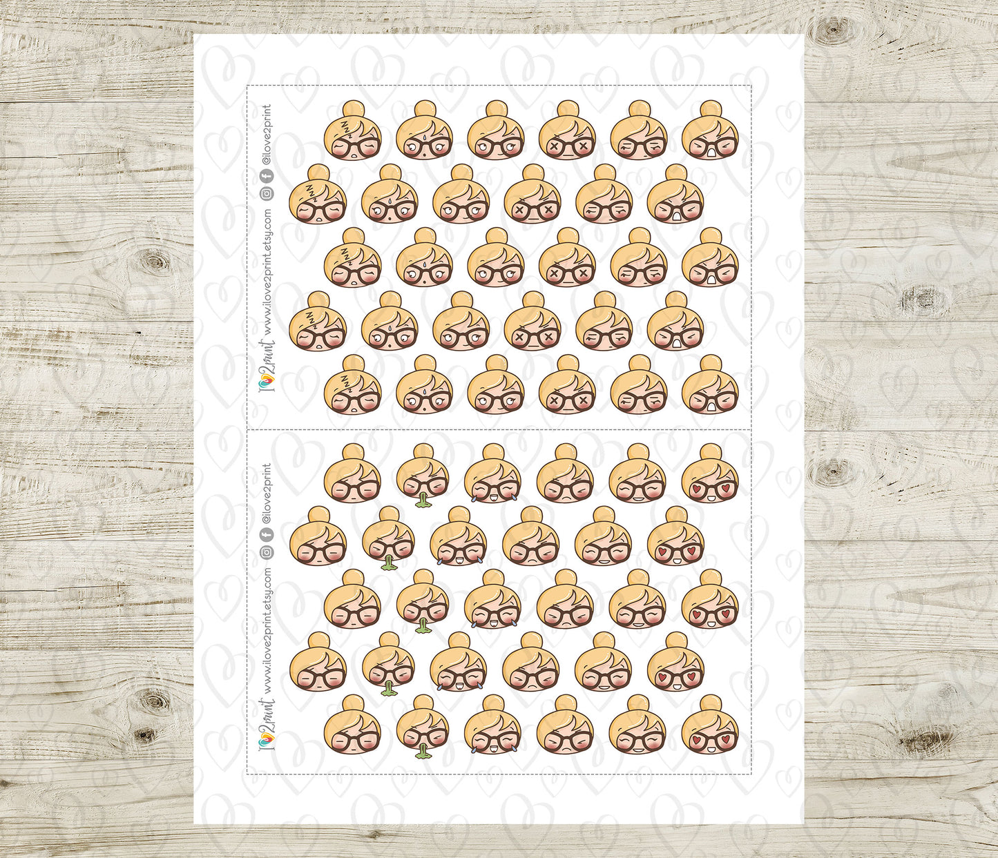 Sheet of planner stickers with various face emojis on a wooden surface