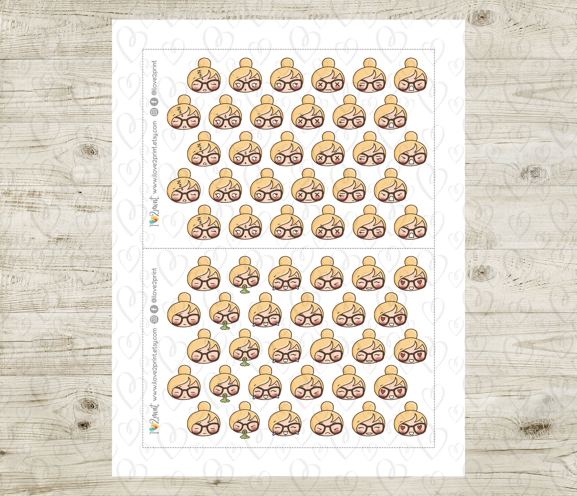 Sheet of planner stickers with various face emojis on a wooden surface