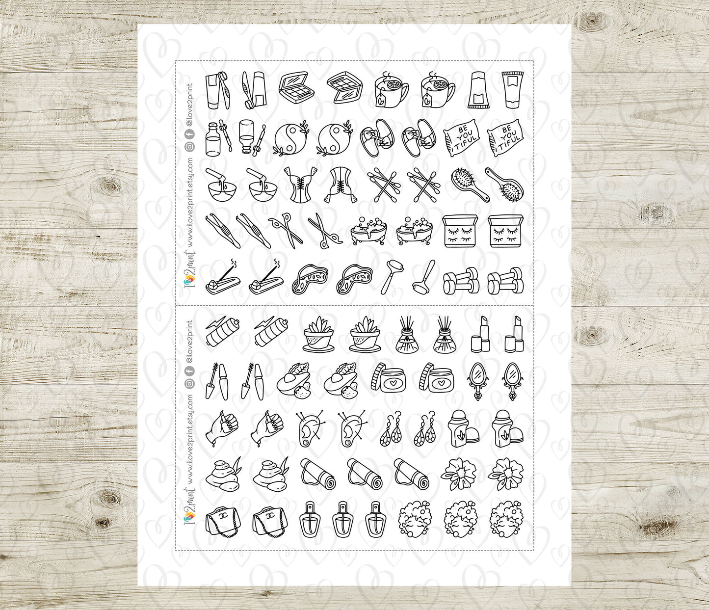 Sheet of black line art icons on a white background, placed on a wooden surface.