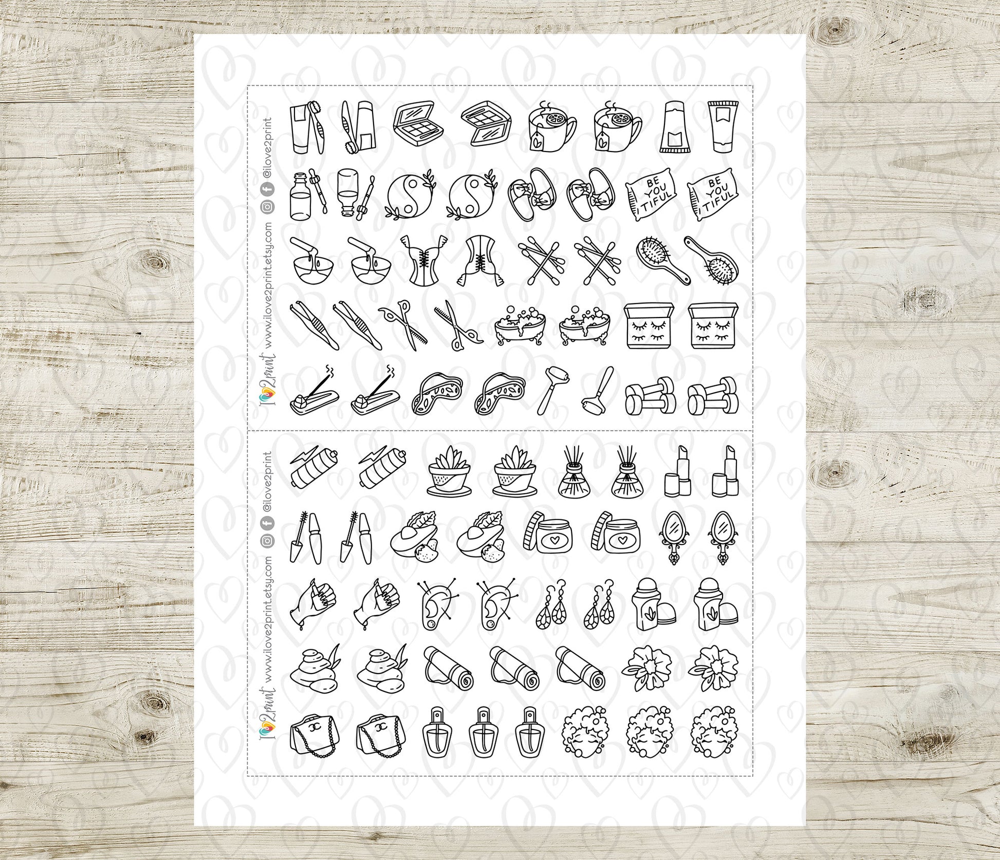 Sheet of black line art icons on a white background, placed on a wooden surface.