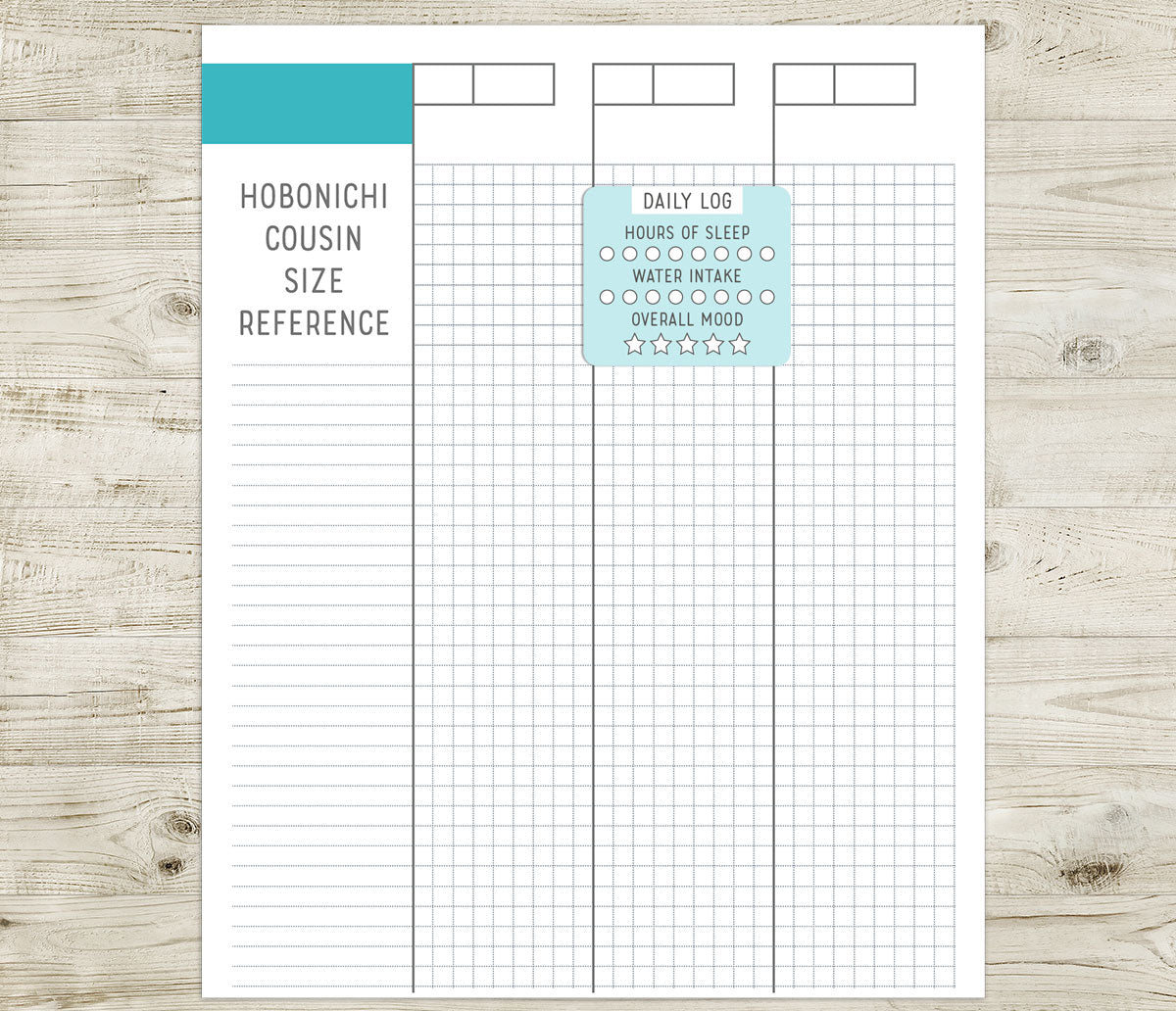 Daily Log sticker on a Hobonichi Cousin size reference sheet with grid layout on a wooden surface
