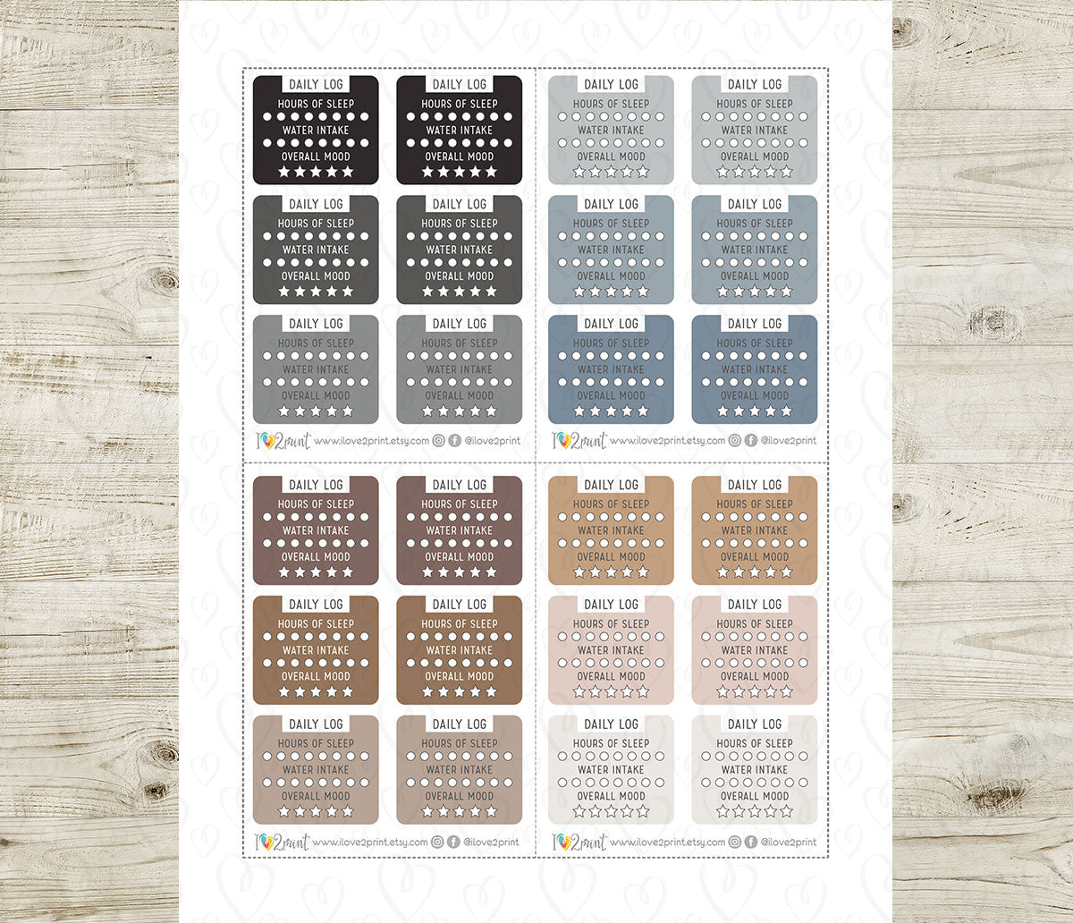 Collection of daily log stickers in various neutral colors on a wooden surface
