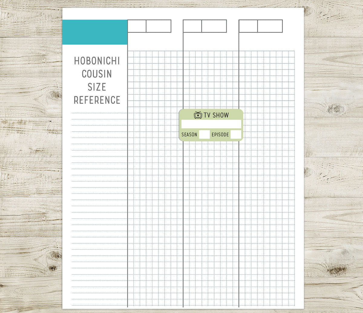 Hobonichi Cousin size reference sheet with grid layout with a TV show sticker on a wooden surface